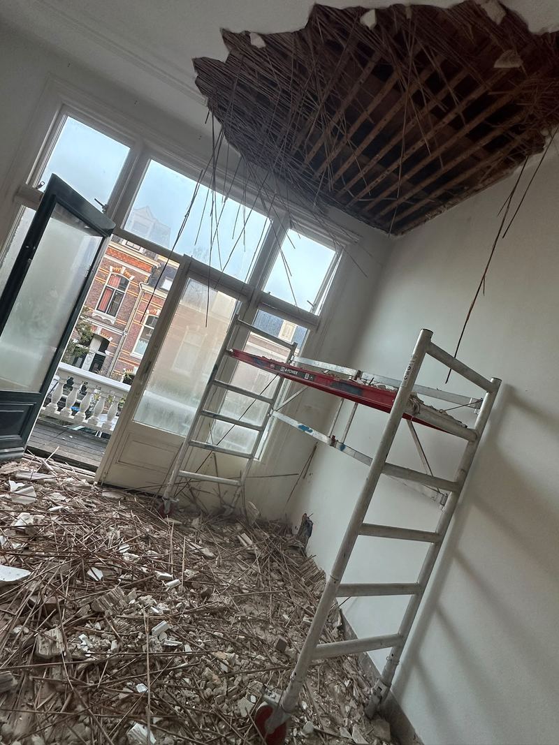 Kamer met verwijderd plafond, rolsteiger en hoge ramen