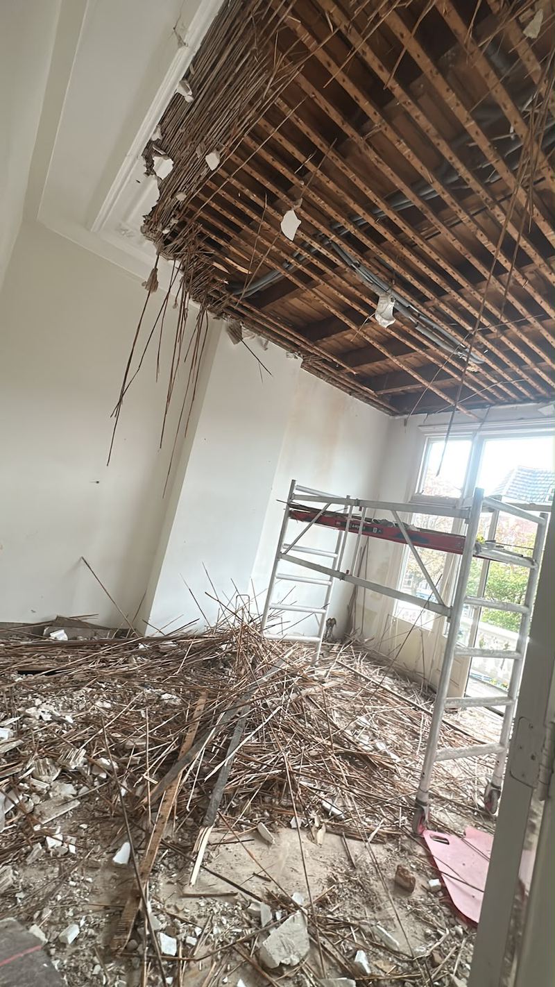 Oud rietplafond verwijderd, puin op de vloer